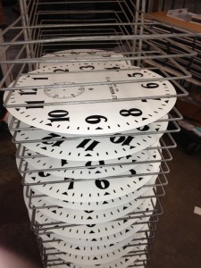 As the dials come out of bake, they are placed in racks to cool.  These are the 14 inch Arabic dials, ready to ship!